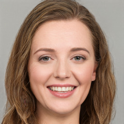 Joyful white young-adult female with long  brown hair and green eyes