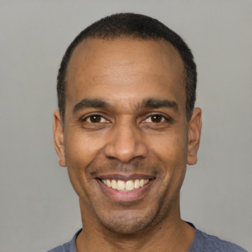 Joyful latino adult male with short  black hair and brown eyes