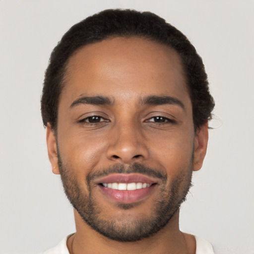 Joyful latino young-adult male with short  brown hair and brown eyes