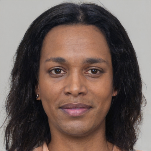 Joyful black adult female with long  black hair and brown eyes