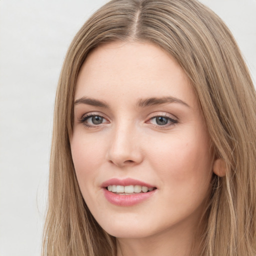 Joyful white young-adult female with long  brown hair and green eyes