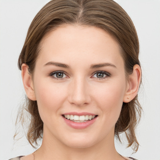 Joyful white young-adult female with medium  brown hair and grey eyes