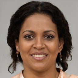 Joyful black adult female with medium  brown hair and brown eyes