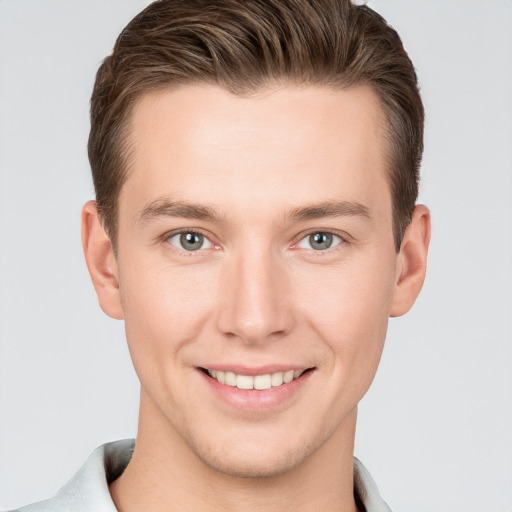 Joyful white young-adult male with short  brown hair and grey eyes