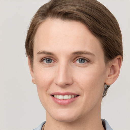 Joyful white young-adult female with short  brown hair and grey eyes