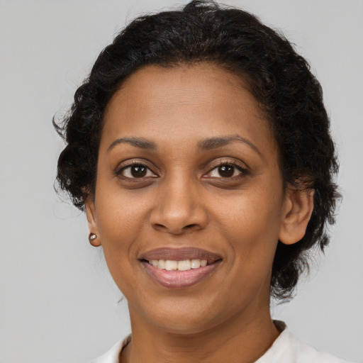 Joyful black adult female with short  brown hair and brown eyes
