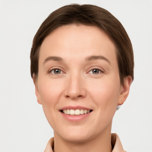 Joyful white young-adult female with short  brown hair and grey eyes