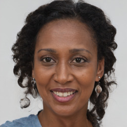 Joyful black adult female with medium  brown hair and brown eyes