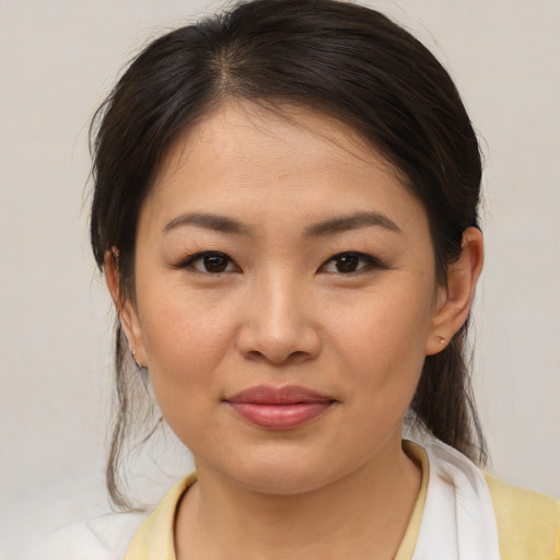 Joyful asian young-adult female with medium  brown hair and brown eyes