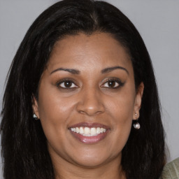 Joyful black young-adult female with long  brown hair and brown eyes