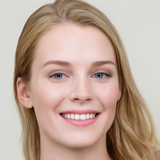 Joyful white young-adult female with long  brown hair and blue eyes