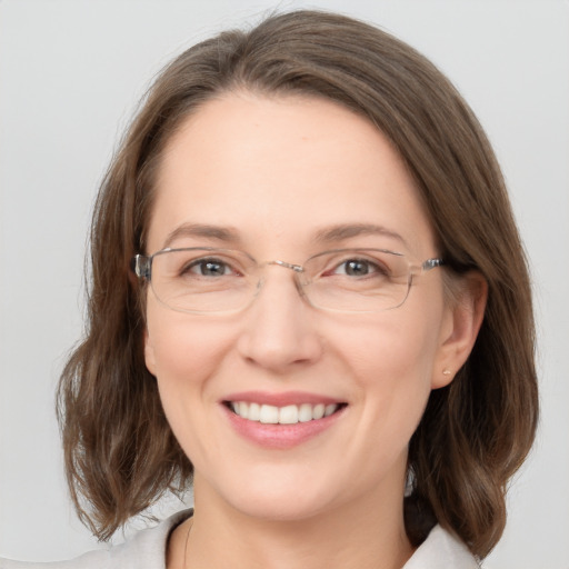 Joyful white adult female with medium  brown hair and green eyes