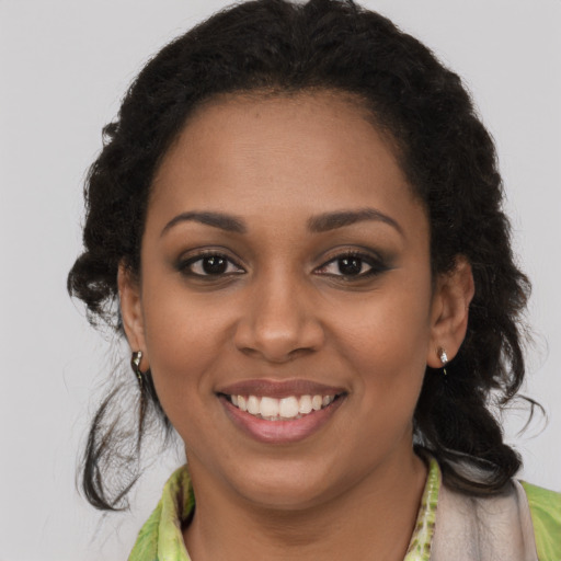 Joyful black young-adult female with long  brown hair and brown eyes