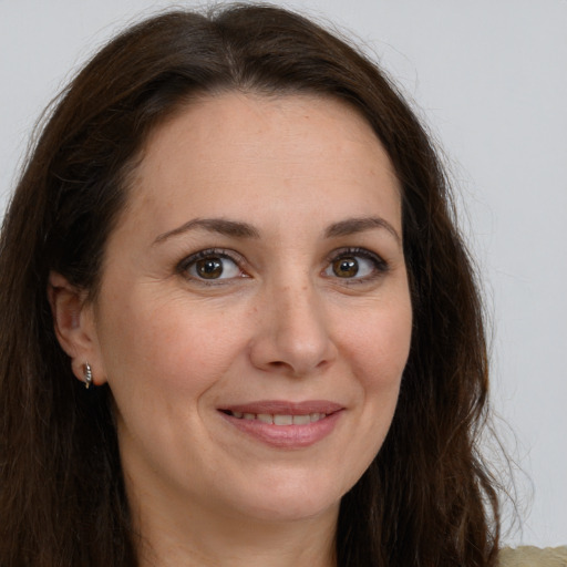 Joyful white adult female with long  brown hair and brown eyes