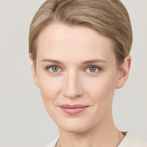 Joyful white young-adult female with short  brown hair and grey eyes