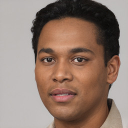 Joyful latino young-adult male with short  black hair and brown eyes