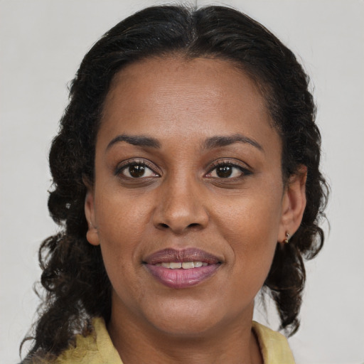 Joyful black adult female with medium  brown hair and brown eyes