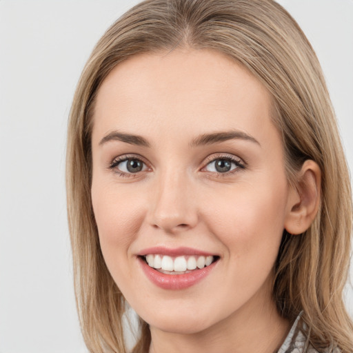 Joyful white young-adult female with long  brown hair and blue eyes