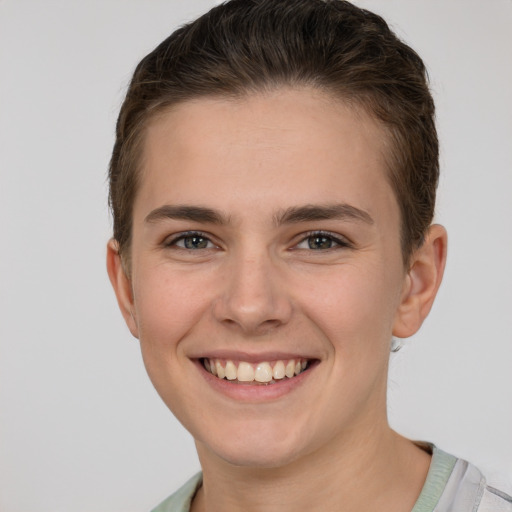 Joyful white young-adult female with short  brown hair and grey eyes