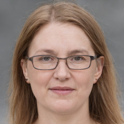 Joyful white adult female with long  brown hair and grey eyes