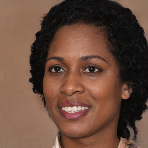 Joyful black young-adult female with medium  black hair and brown eyes