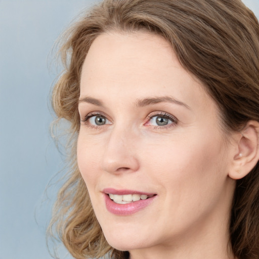 Joyful white young-adult female with medium  brown hair and blue eyes