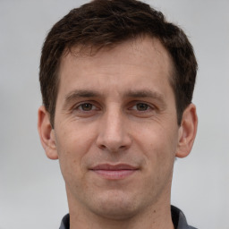 Joyful white adult male with short  brown hair and grey eyes