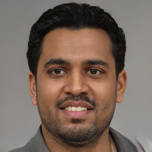 Joyful latino young-adult male with short  black hair and brown eyes