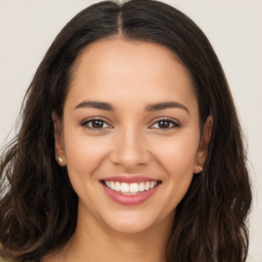 Joyful white young-adult female with long  brown hair and brown eyes