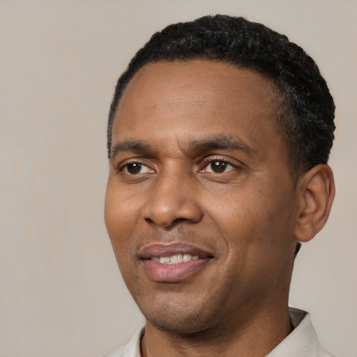 Joyful black young-adult male with short  black hair and brown eyes