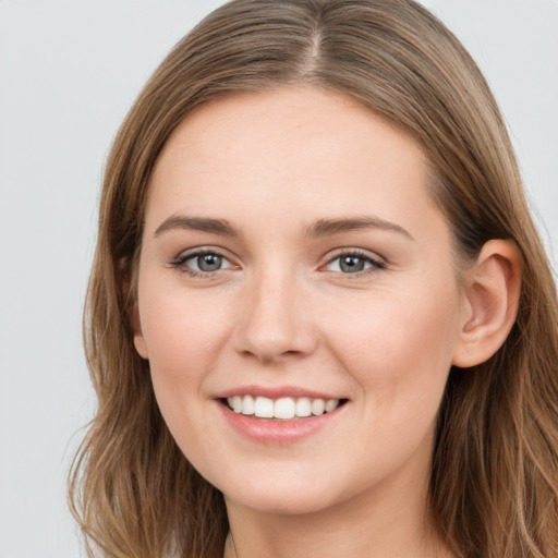 Joyful white young-adult female with long  brown hair and grey eyes