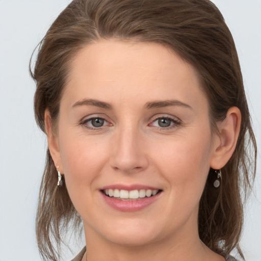 Joyful white young-adult female with medium  brown hair and grey eyes