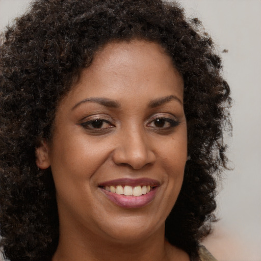 Joyful black young-adult female with long  brown hair and brown eyes