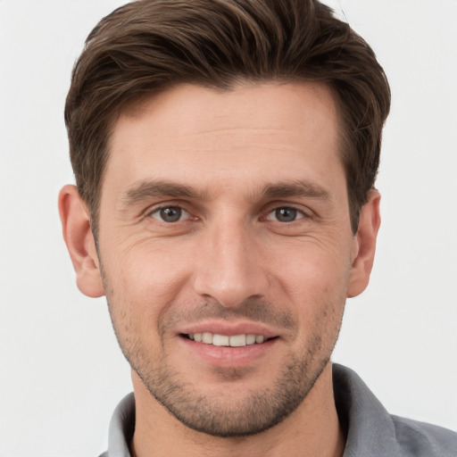 Joyful white young-adult male with short  brown hair and grey eyes