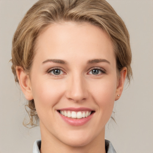 Joyful white young-adult female with medium  brown hair and grey eyes