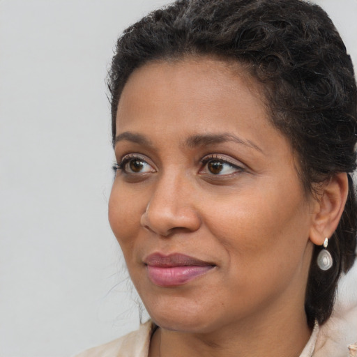 Joyful black adult female with medium  brown hair and brown eyes