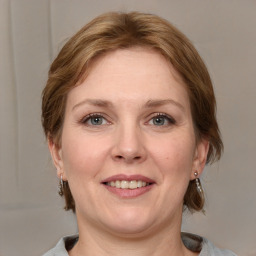 Joyful white adult female with medium  brown hair and grey eyes