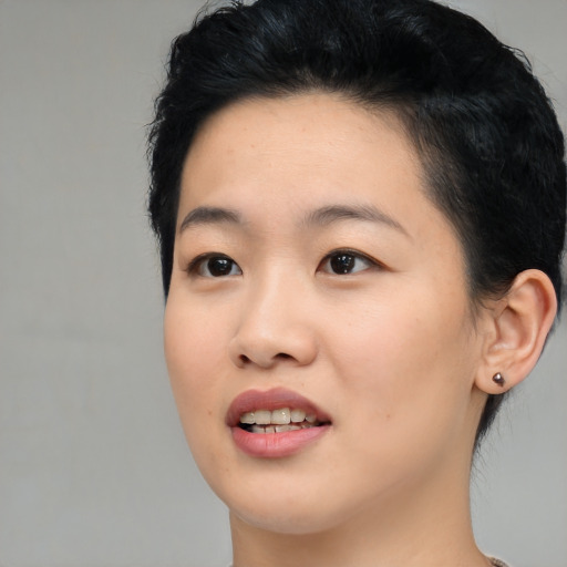 Joyful asian young-adult female with short  black hair and brown eyes