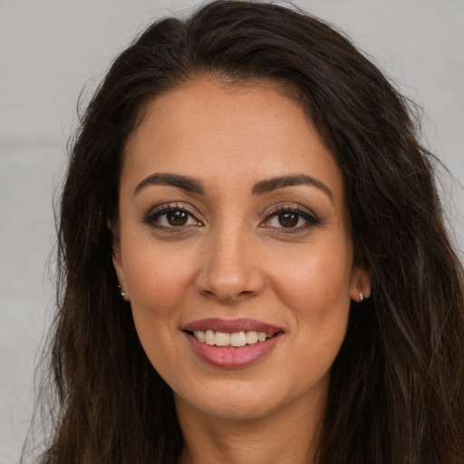 Joyful white young-adult female with long  brown hair and brown eyes