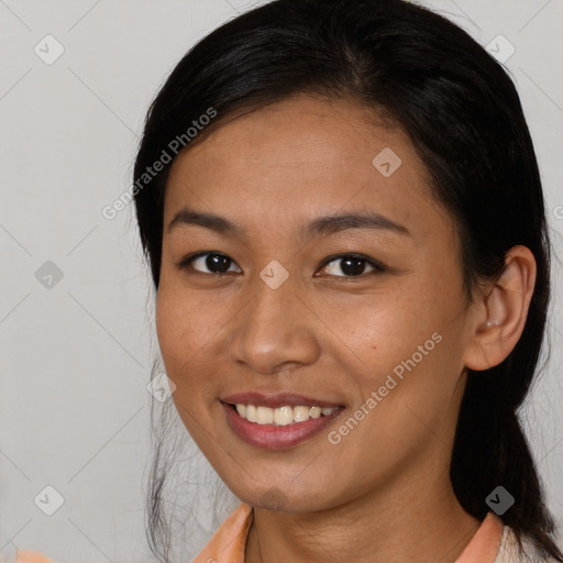 Joyful latino young-adult female with long  brown hair and brown eyes