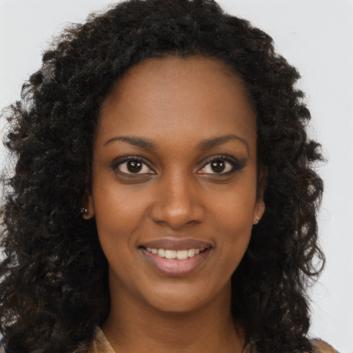 Joyful black young-adult female with long  brown hair and brown eyes