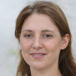 Joyful white adult female with long  brown hair and grey eyes