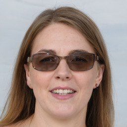 Joyful white young-adult female with long  brown hair and blue eyes