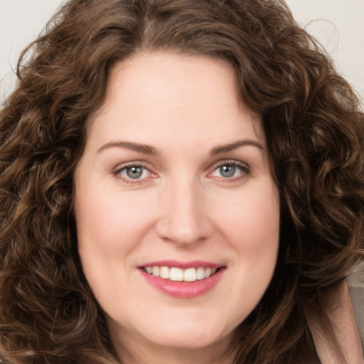 Joyful white young-adult female with long  brown hair and green eyes