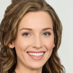 Joyful white young-adult female with long  brown hair and green eyes