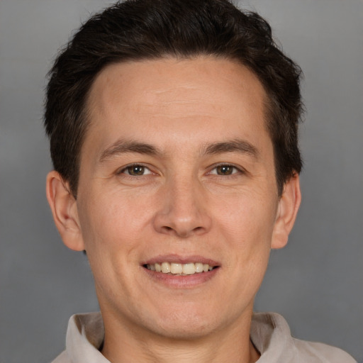 Joyful white adult male with short  brown hair and brown eyes