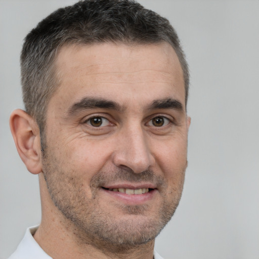 Joyful white adult male with short  brown hair and brown eyes