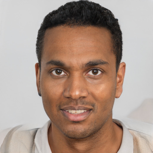 Joyful black young-adult male with short  black hair and brown eyes