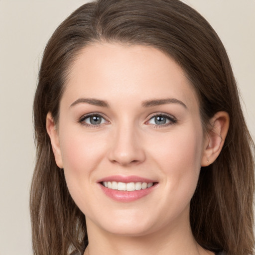 Joyful white young-adult female with long  brown hair and grey eyes