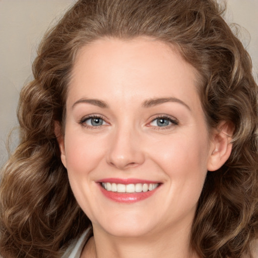 Joyful white young-adult female with long  brown hair and green eyes